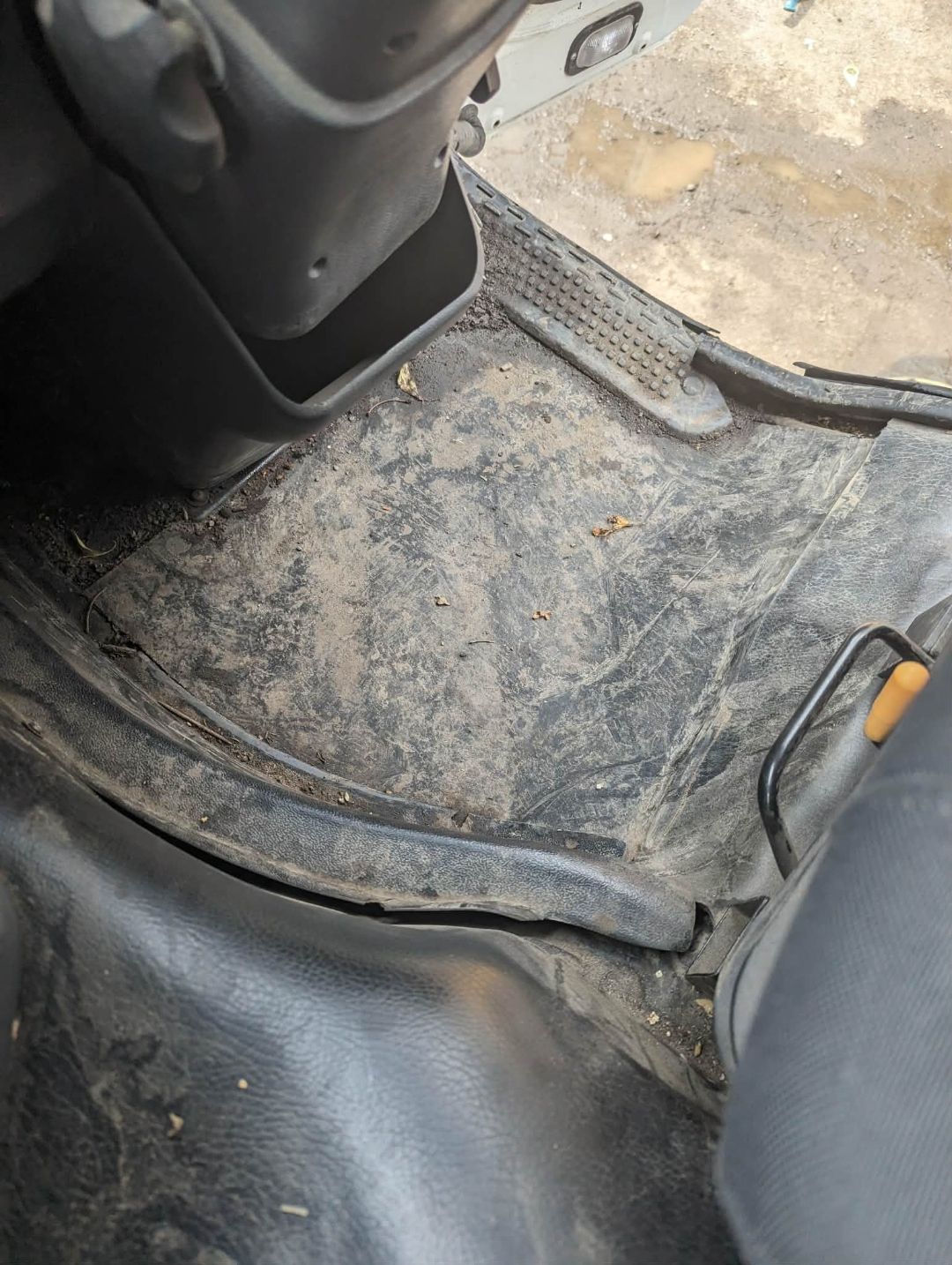 Municipal vehicle cab floor — heavy mud before commercial clean