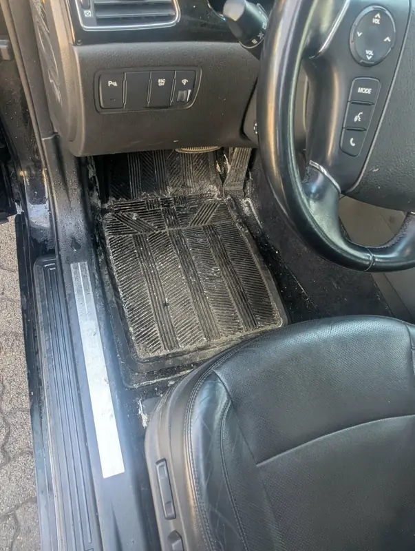 Hyundai Genesis — driver side floor mat heavily dirty with salt before interior detail