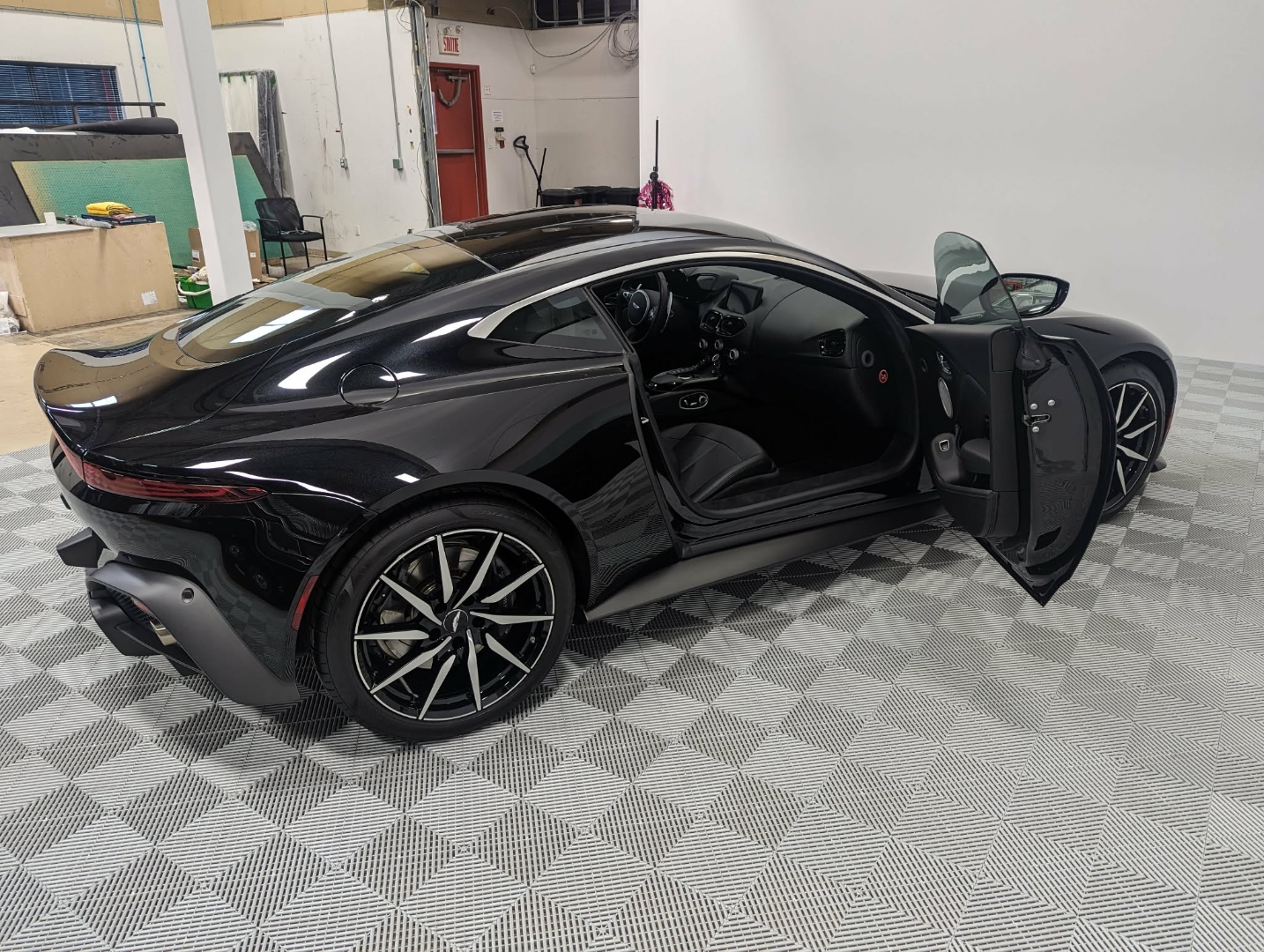 Aston Martin Vantage — rear 3/4 with door open after full detail
